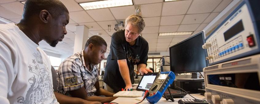 An instructor discussing circuits with two students.